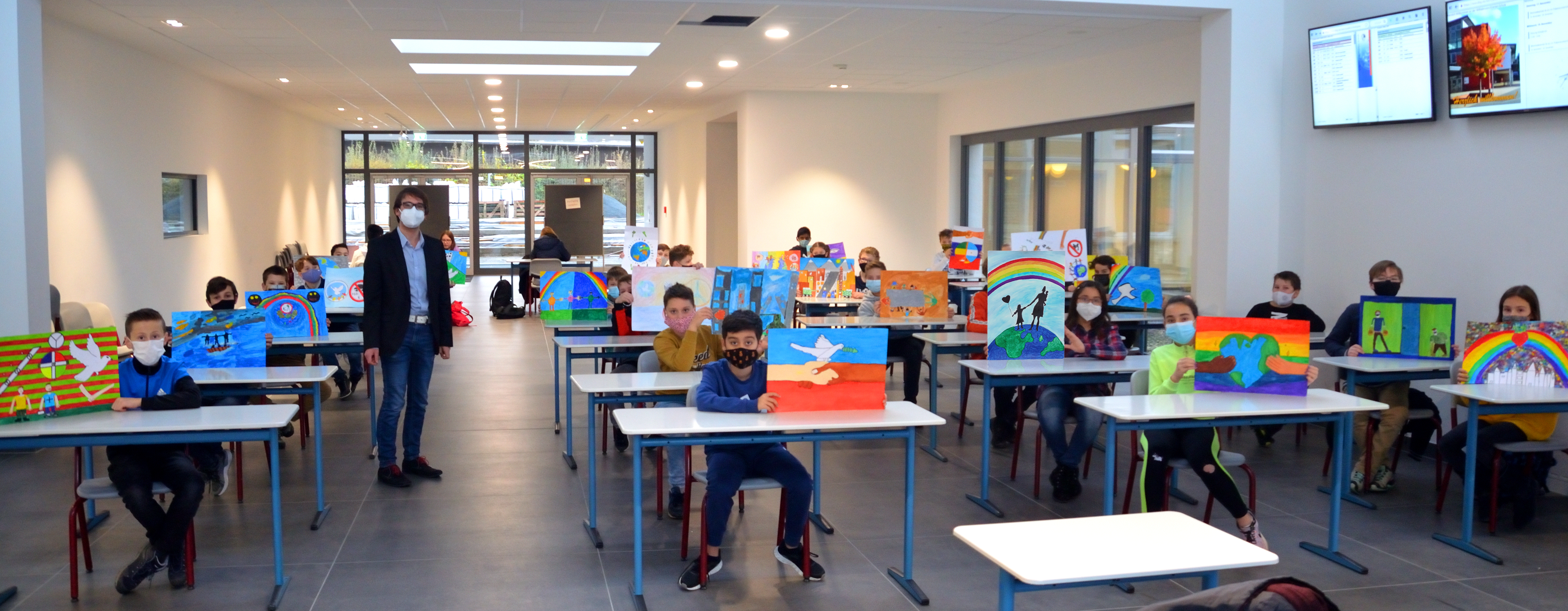 Die Klasse 6 F mit ihren Kunstwerken zum Thema „Frieden durch Hilfsbereitschaft“ und Fachlehrer Sascha Schulze von der Wilhelm-von-Oranien-Schule in Dillenburg.